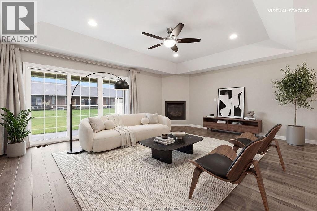 Virtually staged main living room with fireplace and patio doors